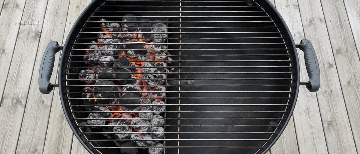 Klotgrill ovanifrån med briketterna samlade på ena halvan och en tom indirekt zon på den andra
