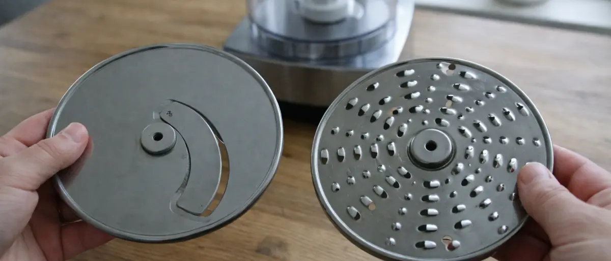 Tillbehör till matberedare utlagda på ett träbord i dagsljus