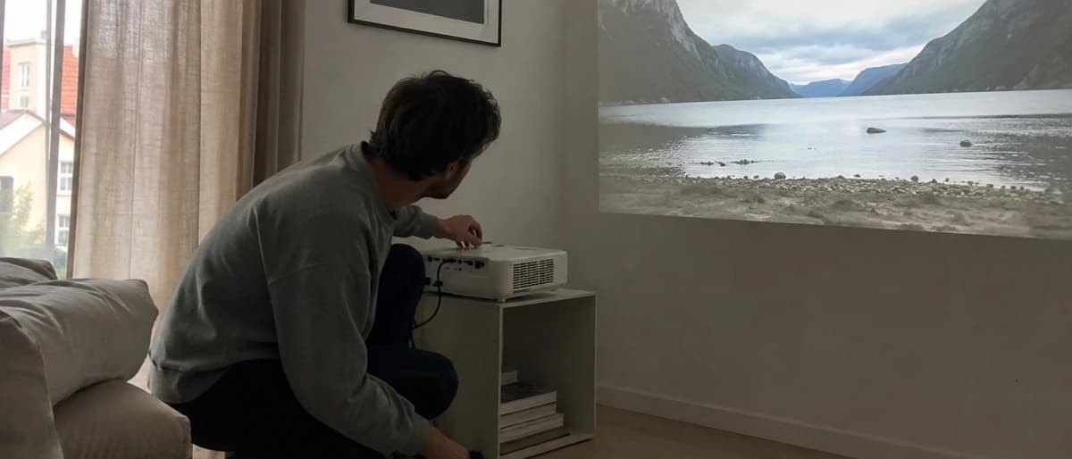 Person som ställer in fokus på en projektor medan en bild visas på väggen