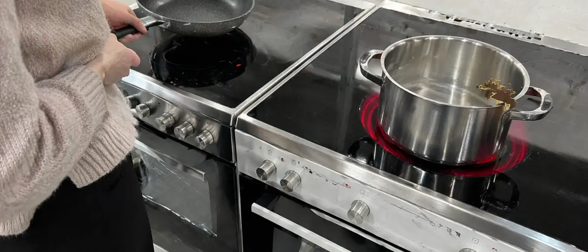Person som testar kokkärl mot induktionshäll inför köp av ny spis